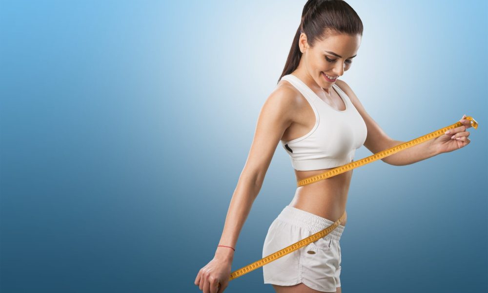 Young fit woman measuring weight loss in Houston, TX | Vida Aesthetics And Wellness