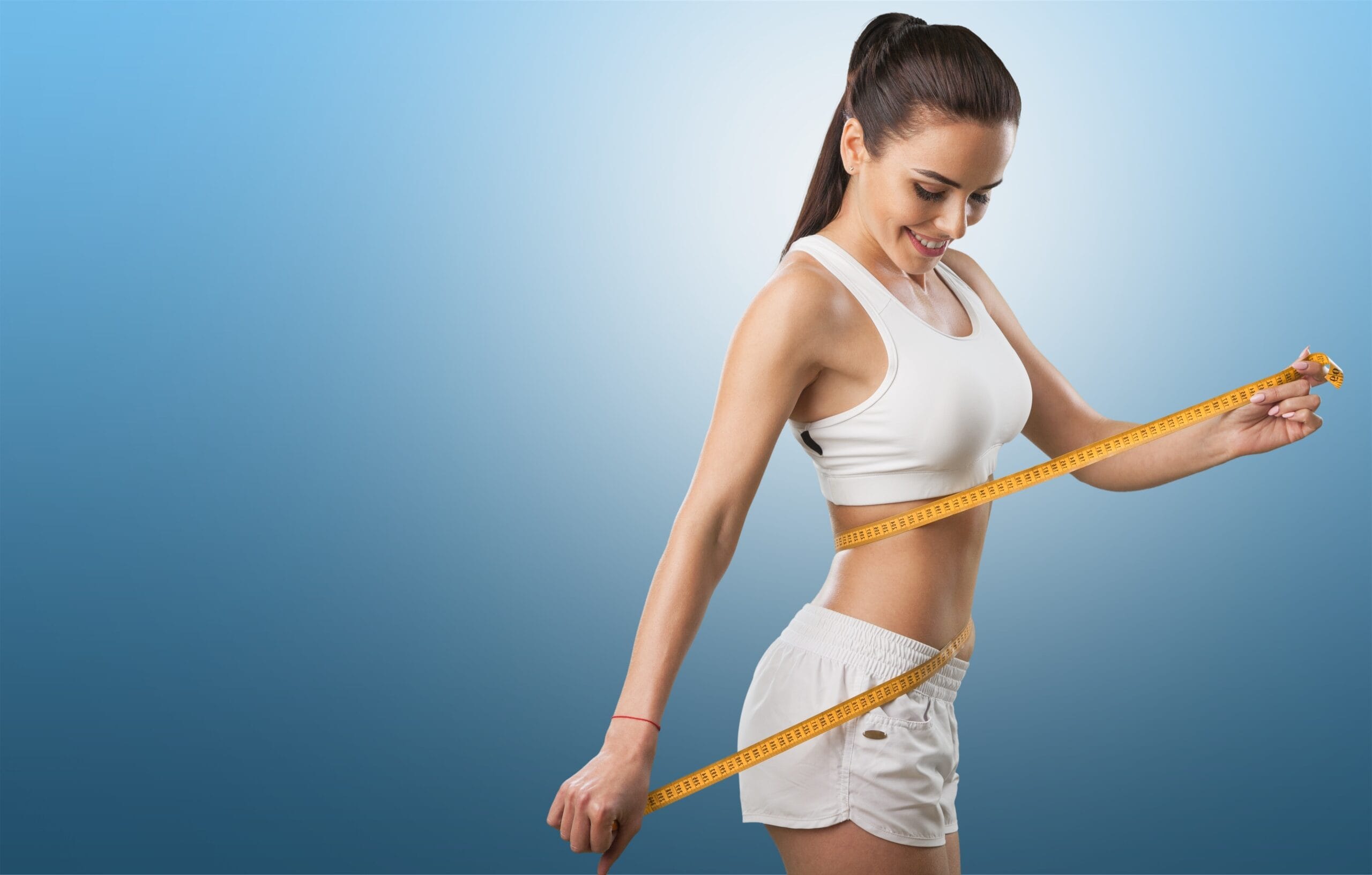 Young fit woman measuring weight loss in Houston, TX | Vida Aesthetics And Wellness